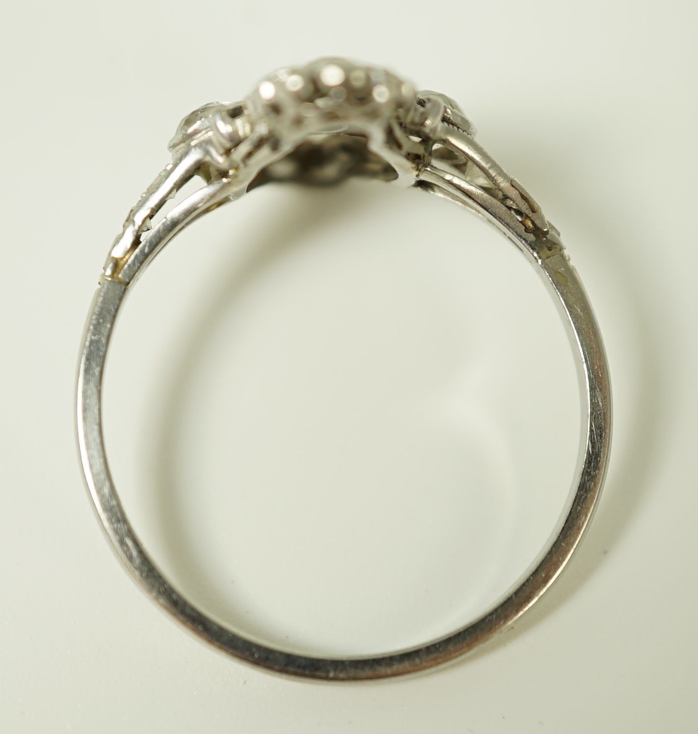 A 1920's platinum and millegrain diamond set flower head cluster upfinger ring